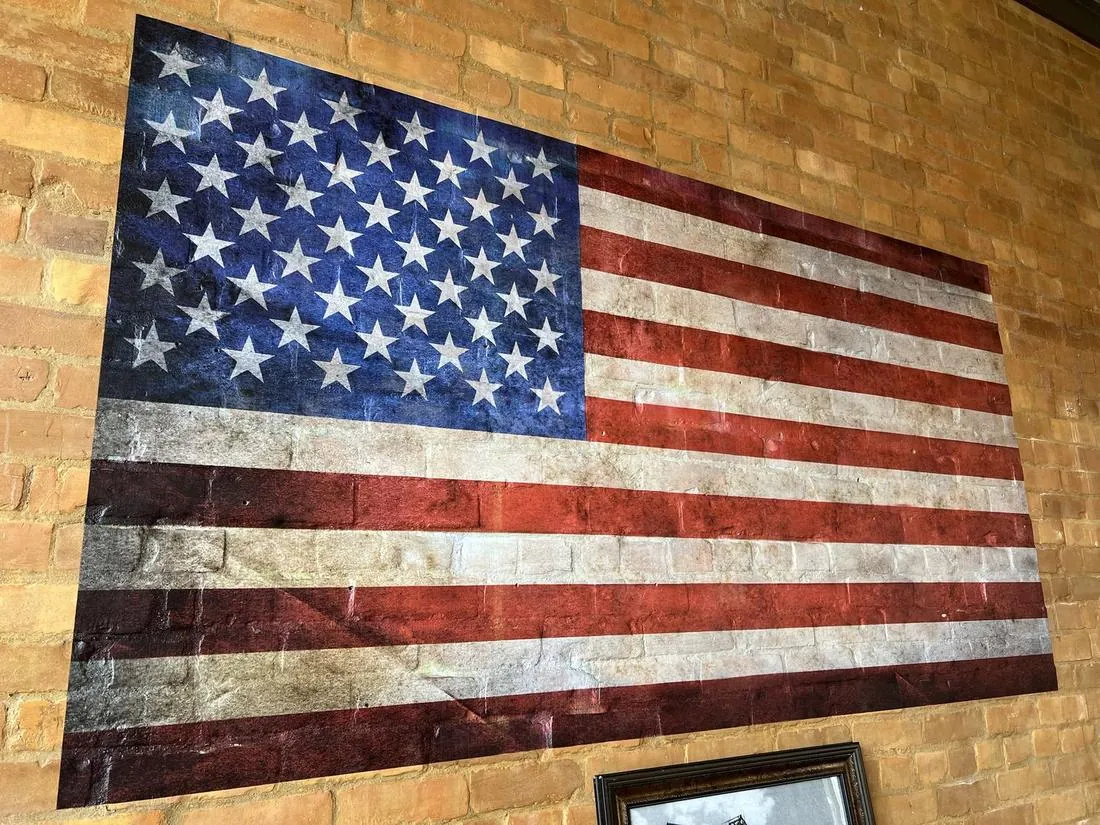 Finished distressed American flag mural printed directly on a brick restaurant wall